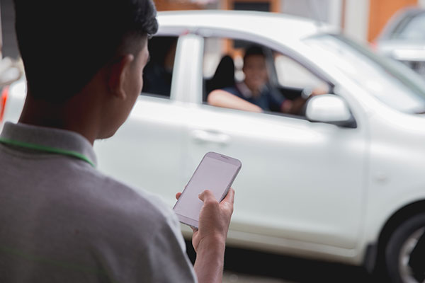 Person with cell phone waiting on a rideshare.